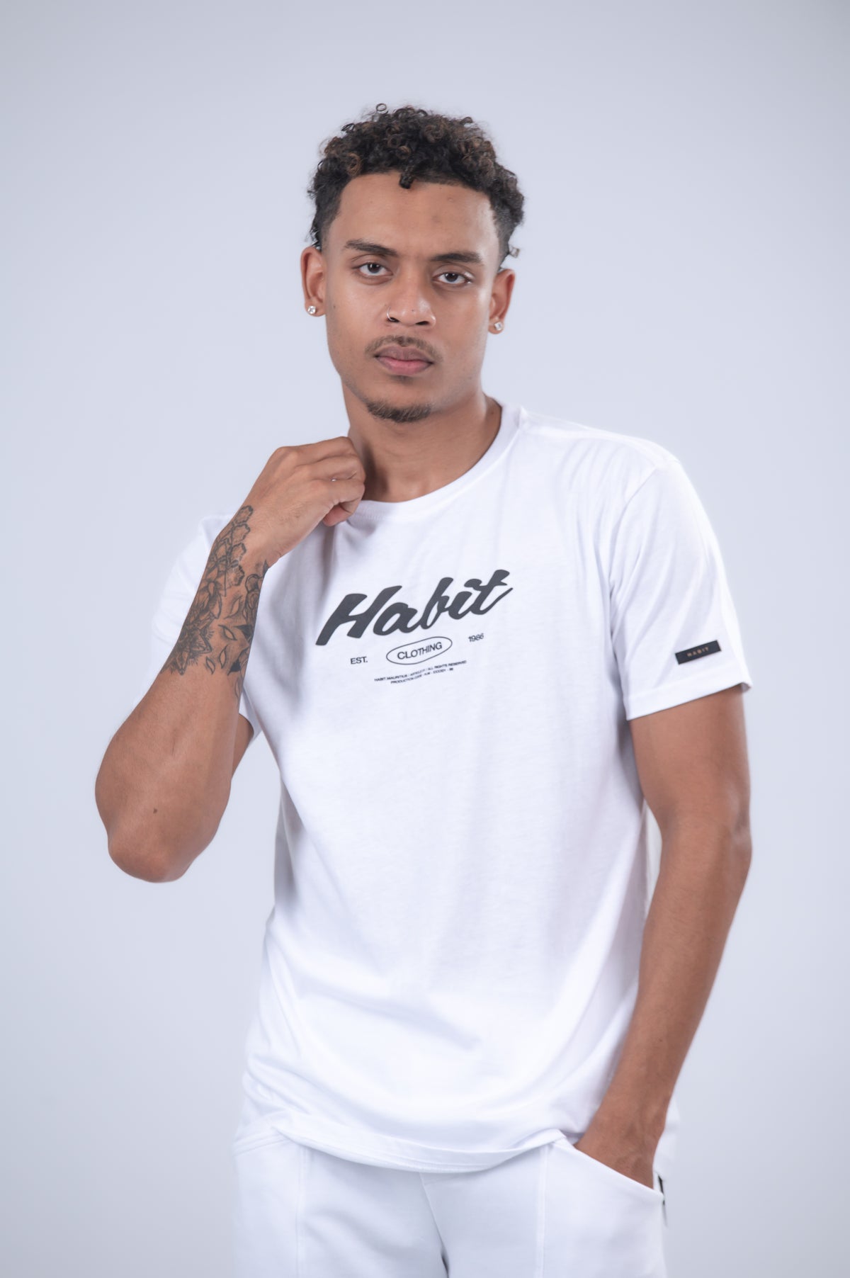 A white short-sleeve t-shirt with a black 'Habit' logo on the chest.