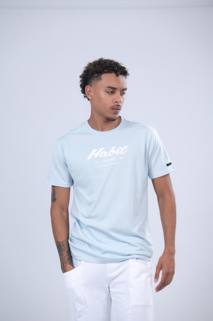 A light blue short-sleeve t-shirt with 'Habit' printed in white script across the chest.